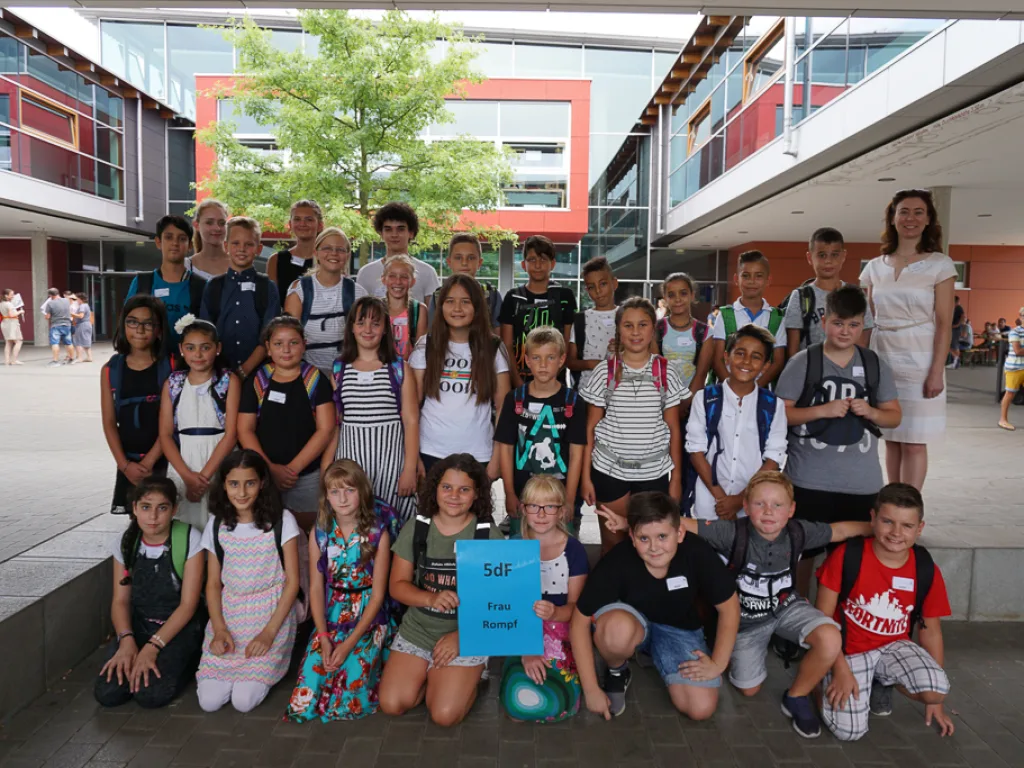 Klassenfoto einer neuen fünften Klasse mit blauem Schild.